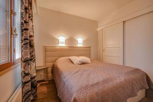 鲁卡Länsirinne 9 C的一间卧室配有一张带两个灯的床