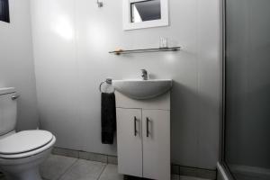 白河SleepOver KMIA的白色的浴室设有水槽和卫生间。