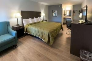 哥伦布Quality Inn & Suites的酒店客房,配有一张床和一张蓝色椅子