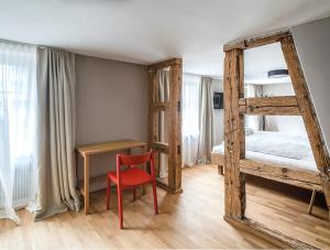 费尔德基希Gasthof Löwen Tosters的一间卧室配有双层床和红色椅子