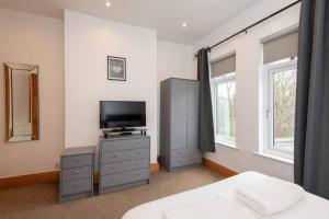 达灵顿Trafalgar Terrace的一间卧室设有一张床、一台电视和窗户。
