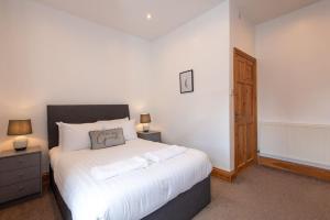 达灵顿Trafalgar Terrace的一间卧室配有一张带两盏灯的大型白色床。