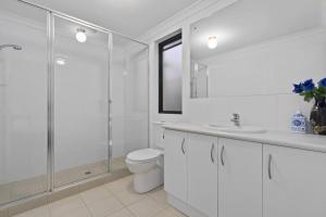 珀斯Modern Family Escapes Shopping at your doorstep的白色的浴室设有卫生间和玻璃淋浴间。