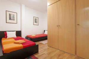 巴塞罗那Key Gracia Apartments的一间卧室配有两张床和一个衣柜