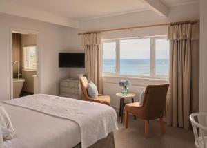 圣艾夫斯Boskerris Hotel的一间卧室设有一张床和一个海景窗户