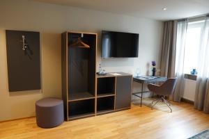 巴特武尔察赫阿德勒酒店的配有书桌和电视的酒店客房