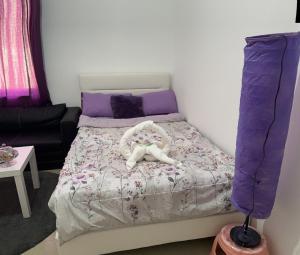 阿布扎比The Purple Place的一间小卧室,配有一张带紫色床单的床