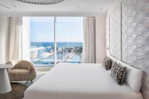巴达洛纳Hotel Marina Badalona的卧室设有一张白色大床和大窗户