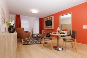尚贝里Chambéry Appart'S的客厅设有橙色墙壁和桌椅
