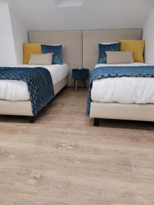 巴塔拉Alojamento Local Vitoria的铺有木地板的客房内的两张床