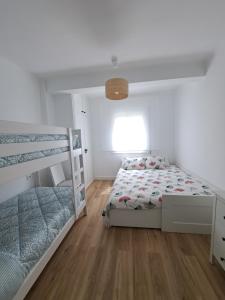 罗达德瓦拉Apartamento vacacional Roda de Barà的一间卧室设有两张双层床,铺有木地板。