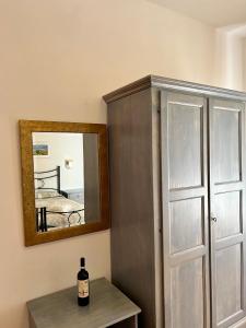 蒙特普齐亚诺马文酒店的镜子旁的桌子上坐着一瓶葡萄酒