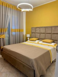 伊斯基亚Exclusive apartment Piccola Marina的一间卧室设有一张大床和黄色的墙壁