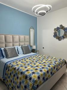 伊斯基亚Exclusive apartment Piccola Marina的一间卧室配有一张大床,床上铺有黄色和蓝色的毯子