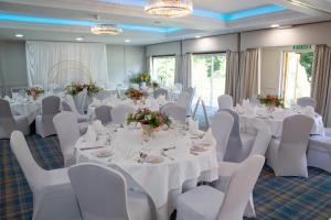 奥尔顿赫里博恩阿尔顿别墅酒店的宴会厅配有白色的桌子和白色的椅子
