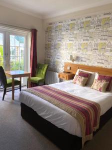 奥尔顿赫里博恩阿尔顿别墅酒店的酒店客房设有床、桌子和窗户。