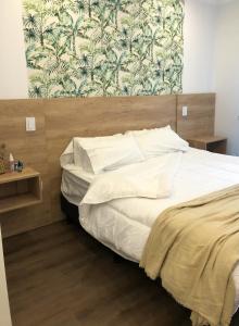 里奥夸尔托Apart IMEB spa & wellness的卧室内的一张带白色床单和枕头的床