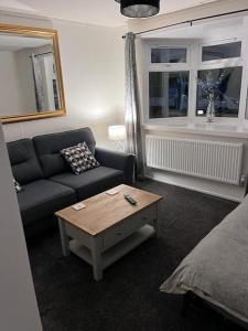 阿丁斯顿Semi-detached chalet - Uddingston, Glasgow的带沙发和咖啡桌的客厅