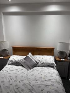 阿丁斯顿Semi-detached chalet - Uddingston, Glasgow的一间卧室配有一张床、两个床头柜和两盏灯。