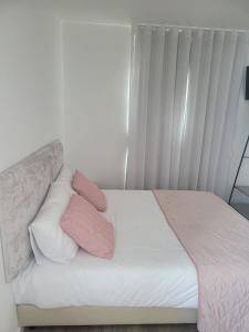 巴塔拉Alojamento Local Vitoria的床上配有粉色和白色枕头的床