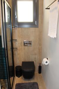 毕达哥利翁Pythagorion Harbour Residence的浴室设有黑色的卫生间和窗户。
