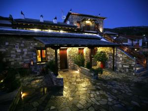 米莱艾Anemoessa Traditional Guesthouse的夜晚外墙灯火的石头房子