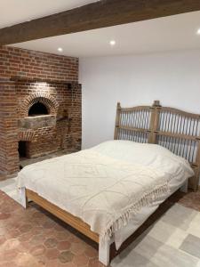 Haute-ÉpineGite de l'épine的一间卧室配有一张床和一个砖砌壁炉