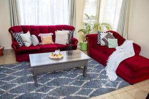 KiambuThe White Dove - At Migaa Golf Estate的客厅配有2张红色沙发和1张咖啡桌