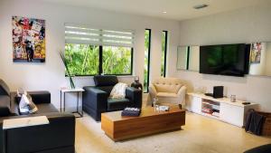 迈阿密Design District by Midtown, Wynwood, Brickell, 10 min to the Beach, FREE PARKING的带沙发和电视的客厅