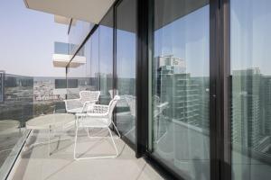 迪拜Revelton Apartment One Residence的大楼内的阳台配有桌椅