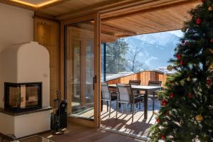 奇勒谷地拉姆绍Chalet Residenz Zillertal Mühlermoos的一间设有桌椅的房间的圣诞树