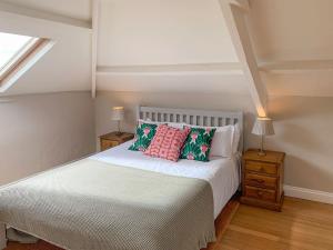Menheniot霍利韦尔谷仓度假屋的卧室配有白色的床和两盏灯。