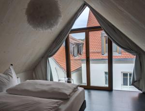 Sulzfeld am MainHotel-Weingut Bernard的一张位于带大窗户的房间内的床铺
