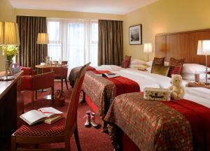特拉利菲尔斯包恩特酒店的酒店客房设有两张床,椅子上摆放着泰迪熊