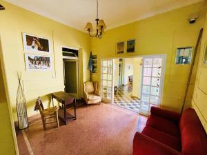 圣安东尼奥德阿雷科Areco hospedaje的客厅配有红色的沙发和桌子
