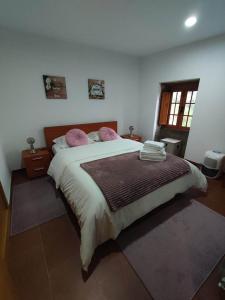 Casa da Laranjeira的卧室配有一张带粉红色枕头的大床