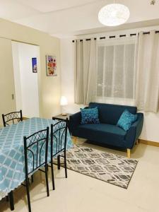 马尼拉SM Southmall condo 2br unit with mall view的客厅配有蓝色的沙发和床。