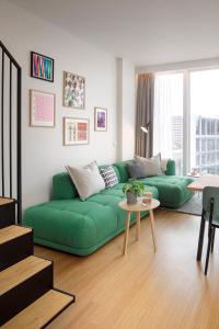 巴黎Zoku Paris的客厅配有绿色沙发和桌子