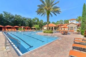 达文波特Near Disney w/ pool-3BR/2BA-Spacious & Cozy Condo的一个带椅子和棕榈树的度假村游泳池