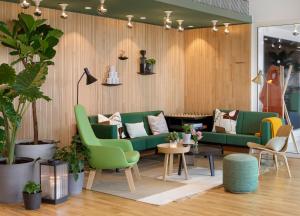 巴黎Zoku Paris的客厅配有绿色沙发和植物