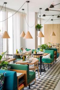 巴黎Zoku Paris的用餐室配有桌子和绿色椅子