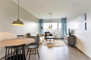 赫尔辛基赫尔辛基拉宾拉登卡图弗恩诺姆服务式公寓的厨房以及带桌椅的起居室。