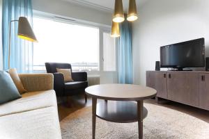 赫尔辛基赫尔辛基拉宾拉登卡图弗恩诺姆服务式公寓的带沙发、电视和桌子的客厅