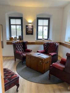 奥泊维森塔尔Fasa Lodge的客厅配有两把椅子和一张桌子及一个箱子