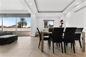 Ayios DhometiosGlabur Stays - The Luxurious 3 BDR - Cozy apt Newly Renovated, Nicosia City的一间带桌子和黑色椅子的用餐室