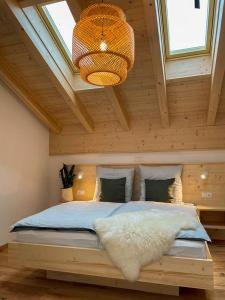 阿尔恩布鲁克Bayerwald Chalet Kaitersberg mit Sauna, Sonnenterrasse und Garten的卧室设有一张木制天花板上的大床