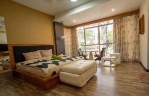 乔治市Cozy Gurney Georgetown Private Apartment Penang的卧室配有床、椅子和窗户。