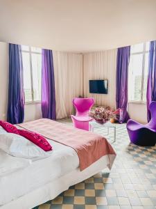 滨海阿热莱斯B&B Château Valmy - Teritoria的一间卧室配有一张大床和紫色家具