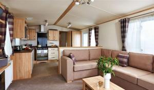 佩恩顿Hoburne Devon Bay Stunning 3 bed static caravan with full decking的带沙发的客厅和厨房
