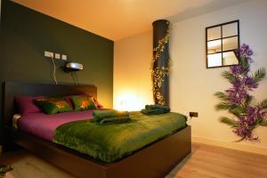 布雷得佛NEW Luxury NYC Style Loft with Cinema Room的一间卧室配有一张带绿色床单和鲜花的床。